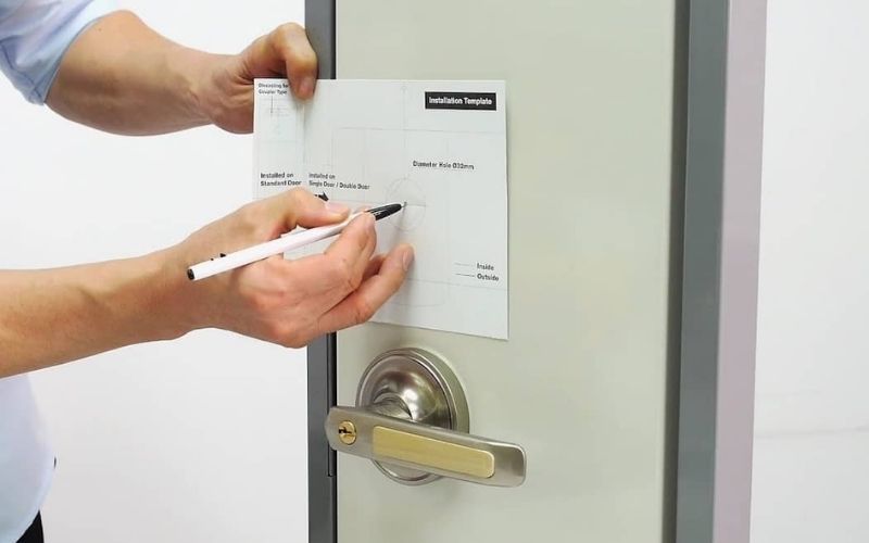 Kỹ thuật viên Kaadas đang tiến hành đo đố cửa và lắp đặt khóa điện tử cao cấp